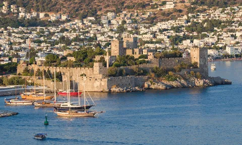 Bodrum Castle's stone towers overlooking a marina filled with moored boats