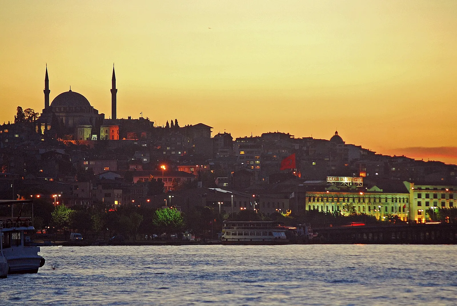 Golden-hour view over the Golden Horn from Galata Bridge with the Fatih Mosque in the distance