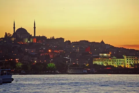 Golden-hour view over the Golden Horn from Galata Bridge with the Fatih Mosque in the distance